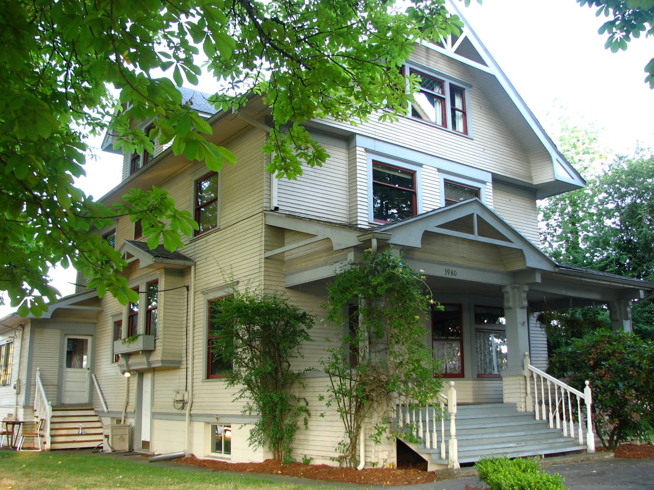 Blanton House in Beaverton, Oregon, with wood siding, a porch and mature trees