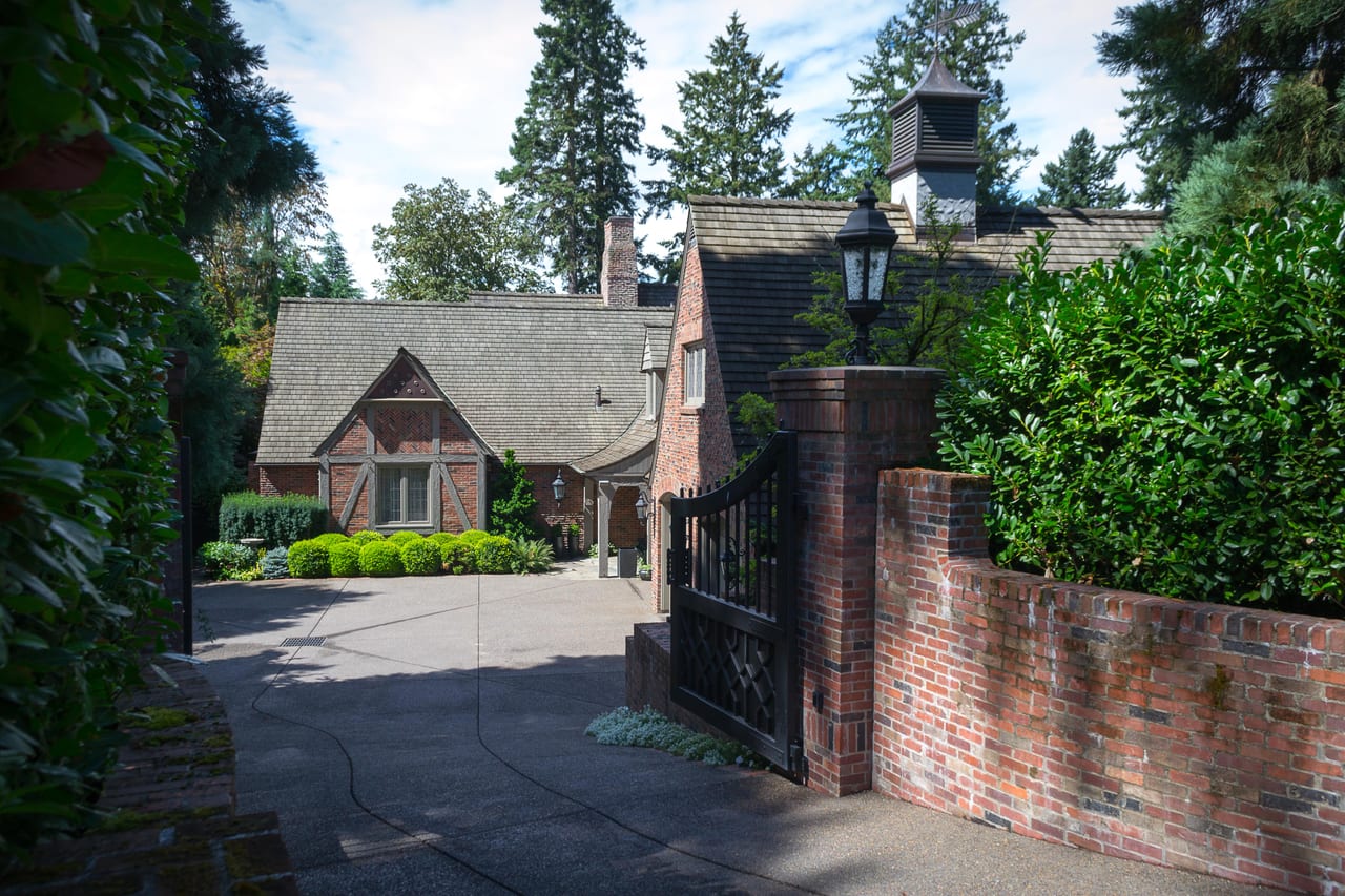Clarence Francis House in Milwaukie, Oregon, with brickwork, steep roofs and evergreen trees